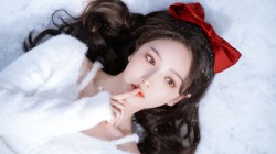 躺在雪地的美女 长发 红色蝴蝶结 好看白色毛衣美女壁纸
